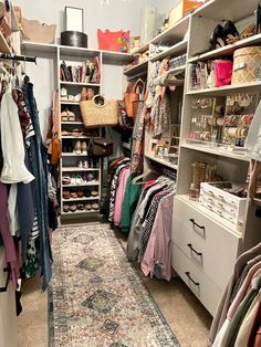 an organized closet with lots of clothes and shoes on the shelves, drawers, and rugs