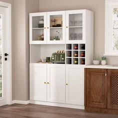 a kitchen with white cabinets and wood floors