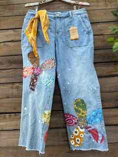 a pair of jeans with patches and flowers on them