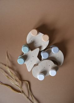 three wooden toys sitting next to each other on a brown surface with some dry grass