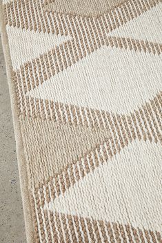 a beige and white rug on the ground