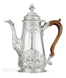 a silver teapot with wooden handles and an ornate design on the top, sitting on a white surface