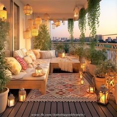 an outdoor living area with lots of plants and candles on the floor, in front of a balcony