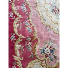 a pink and gold rug with flowers on it