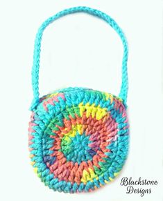 a crocheted bag with a handle is shown in multi - colored yarn and sits on a white surface