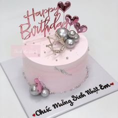 a pink birthday cake decorated with pearls and hearts