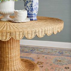 a wicker table topped with two vases filled with flowers