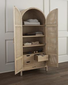 an open wooden cabinet with drawers and doors on the front, in a white room