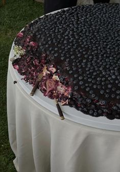 a large chocolate cake sitting on top of a table covered in blueberry toppings