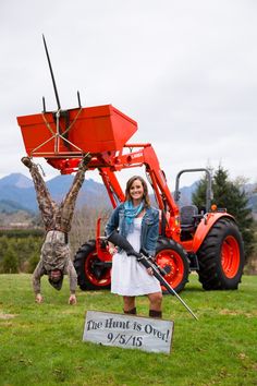 a woman standing in front of a red tractor with the caption, now that's how you take engagement photos