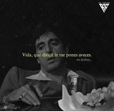 a man sitting at a table with a drink in his hand and the words vida, que diffiti te me pones aveces