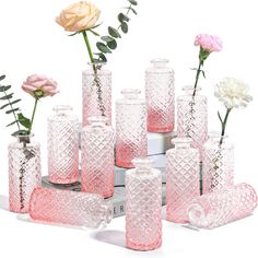 a group of pink vases sitting next to each other on top of a table