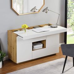 a white desk with drawers and a mirror on the wall in a modern living room