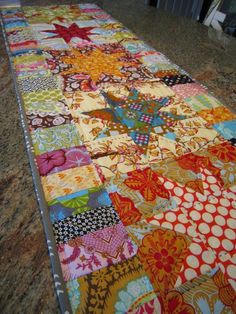 a very large colorful patchwork quilt on the ground