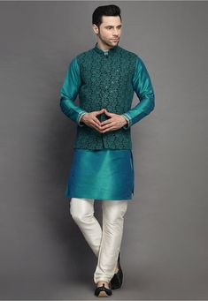 Art Silk Kurta in Teal Blue This Readymade attire is Enhanced with Buttons, Resham and Sequins Work. Crafted in Chinese Collar Neck and Full Sleeve Available with an Art Silk Churidar in Off White and a Faux Georgette Nehru Jacket in Dark Green Do note: Footwear shown in the image is for presentation purposes only. Half to one inch may vary in measurement. (Slight variation in actual color vs. image is possible) Traditional Long Sleeve Turquoise Kurta, Fitted Blue Outerwear With Chikankari Embroidery, Green Embroidered Winter Sets, Blue Floral Embroidered Outerwear For Wedding, Blue Long Sleeve Outerwear With Intricate Embroidery, Blue Fitted Outerwear For Designer Wear, Fitted Blue Outerwear For Designer Wear, Blue Spring Wedding Outerwear, Spring Wedding Blue Outerwear