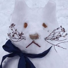 a snowman made to look like a cat with branches on it's head