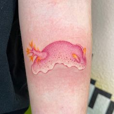 a pink gecko tattoo on the arm