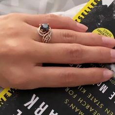 a woman's hand with a ring on top of a book