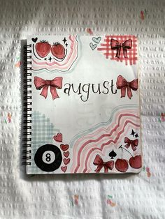 a spiral notebook with the words august written on it