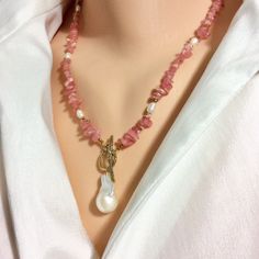 "Delicate and romantic necklace composed of rhodochrosite nuggets gemstone with beautiful shades of translucent pinks mixed with gold hematite beads and natural freshwater pearls. I added an artisan gold bronze toggle clasp holding a large baroque pearl to compliment the look. You can wear this beautiful necklace as displayed in pictures or throw the closure to the back if you have a decollete dress. MATERIALS: Rhodochrosite nugget beads Freshwater rice pearls Freshwater baroque pearl 22x12mm Gold coated hematite beads Gold Bronze Toggle clasp Measures 20\"inches or 51cm approx All Loulia Pearl Jewelry orders are carefully packaged in a jewelry box with foam insert and secured with a ribbon for safe delivery. You will also get a beautiful jewelry pouch to store your piece of jewelry. Invoi Pink Polished Beads Pearl Necklace As A Gift, Pink Polished Bead Pearl Necklace For Gifts, Pink Polished Beads Pearl Necklace For Gifts, Pink Polished Bead Necklace For Gift, Pink Polished Beaded Necklaces For Gifts, Pink Necklace With Polished Beads For Gift, Pink Polished Pearl Necklace For Gift, Pink Necklaces With Polished Beads For Gifts, Pink Pearl Jewelry With Natural Stones