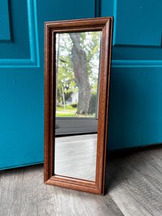 a mirror sitting on the ground next to a blue door