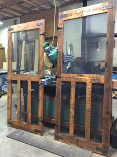 two large wooden windows sitting inside of a building next to other wood and metal items