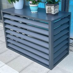 two potted plants sit on top of a blue cabinet