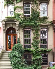 an old building with ivy growing on it's side and stairs leading up to the door