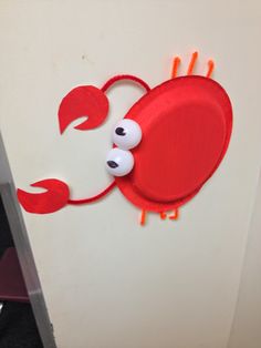 a red plate with googly eyes and an eyeball in the shape of a crab