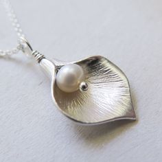 Silver Calla Lily Necklace - Gift for Her Classic and elegant gift for mother, friend or for bridesmaids. Dainty, easy to wear everyday or on special occasions. FEATURES: * A small freshwater pearl is wire wrapped with bright calla lily petal to form a flower pendant. * The petal is rhodium plated over brass. * Comes with sterling silver chain, finished with spring clasp closure. All sterling silver calla lily necklace: https://www.etsy.com/listing/476943360/ MEASUREMENTS: * the pendant is about Elegant Flower Shaped Necklace For Mom, Elegant Nickel-free Necklace For Mom, Classic Nickel-free Necklace For Wedding, Classic Nickel Free Necklaces For Weddings, Classic Nickel-free Necklaces For Wedding, Elegant White Necklace - Gift For Mom, Elegant Nickel-free Necklaces For Bridesmaid Gift, Elegant Nickel-free Necklace For Wedding, Elegant Silver Necklace - Gift For Mom