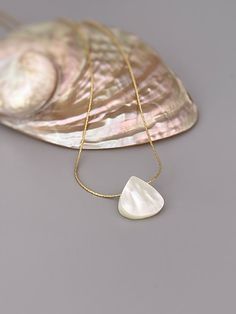 Handmade genuine mother of pearl necklace. A dainty solitaire necklace for women with an iridescent mother of pearl shell on your choice of a delicate sterling silver or 14k gold filled  chain. Perfect summer or beach wedding necklace. A simple, elegant pendant necklace perfect for everyday wear.  Beachy summer jewelry Mother of Pearl size: 14mm tall x 14mm wide (approx 1/2") PLEASE note measurements and size reference pictures. Our jewelry and hair accessories are photographed close up to show Elegant Shell-shaped Jewelry With Pearl Charm, White Shell-shaped Jewelry With Pearl Pendant, White Shell-shaped Pearl Pendant Jewelry, Elegant Shell Necklace With Clavicle Chain As Gift, Elegant Shell-shaped Clavicle Jewelry, Elegant Shell Jewelry For Anniversary, Elegant Clavicle Chain Shell Necklace As Gift, Shell Necklace With Round Pendant As A Gift, White Shell-shaped Necklace For A Gift