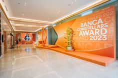 an award display in the lobby of a hotel or conference room with orange and green accents