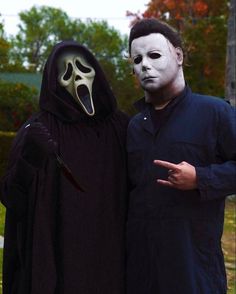 two people dressed in halloween costumes standing next to each other, one wearing a mask and the other holding a knife