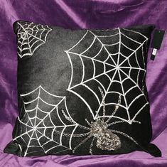 a black and white spiderweave pillow on a purple background