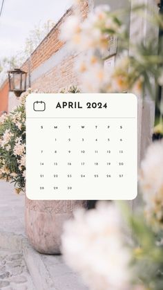 an image of a calendar with flowers in the foreground and a brick building in the background