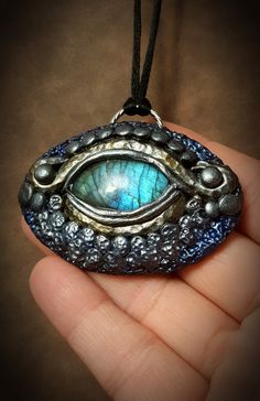 "**insurance included free of charge on all orders of $50 or more This Ice Dragon pendant is a part of my Dragonfire collection, which embodies the strength, beauty, magic, and fire of dragons! This stylized Ice Dragon pendant was created and sculpted from polymer clay to look like a dragon eye, using a gorgeous blue flash Labradorite cabochon as the focal \"eye\" stone! It was colored with blue, silver, and crystal pigments to give this an icy feel! This was also sealed upon completion! This wa Polymer Pendant, Dragon Eyes, Wiccan Decor, Raven Pendant, Ice Dragon, Elven Jewelry, Odd Things, Beauty Magic, Clay Crafts Air Dry