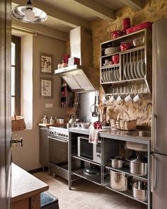 a kitchen with lots of pots and pans on the shelves above the stove top