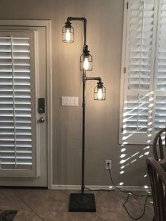 a lamp that is sitting on top of a floor in front of a door with shutters