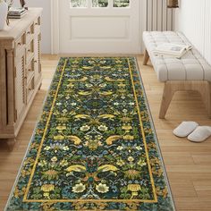 an ornately decorated rug in a room with white walls and wooden flooring, along with a bench