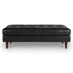 a black leather bench with wooden legs