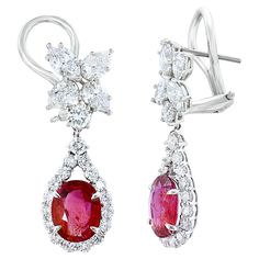 A beautiful and chic pair of drop earrings showcasing a cluster of brilliant mixed-cut diamonds, and certified oval brilliant cut NATURAL RUBY set in an intricate and stylish design. 8 Mixed cut Diamonds weigh 1.62 carats in total. 2 natural rubies weigh 4.85 carats in total. Made in 18k white gold. 36 accent diamonds weigh 2.22 carats in total. The color of these gemstones is ideal, with great luster/shine. Omega clasp with a post. Exquisite White Ruby Jewelry, Fine Jewelry Ruby Earrings With Brilliant Cut, Ruby Brilliant Cut Fine Jewelry Earrings, Exquisite Red Ruby Earrings, Luxury White Ruby Earrings, Diamond Drop Earrings, Diamond Drops, Ruby Diamond, Natural Ruby