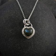 This handcrafted necklace features a hand-carved labradorite gemstone heart set in a subtly textured and sterling silver setting.  The pendant hangs from a delicate yet durable sterling silver rolo chain.   Made with love and finished to our exceptional standards, this necklace is unique & perfect for everyday wear. Handmade in Sechelt in our little Sunshine Coast studio.   Product Details: *This necklace is ready to ship.  Will ship within 3 business days of ordering. *Sterling silver and labra Sterling Silver Heart Necklace With Gemstone, Dainty Sterling Silver Heart Gemstone Necklace, Unique Jewelry Gifts, Dark Heart, Heart Gemstone, Handcrafted Necklace, Necklace Gemstone, Labradorite Pendant, Rolo Chain