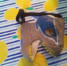 a paper mache of a dinosaur head on a blue and yellow background with lemons