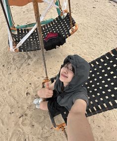 a person sitting in a hammock on the beach