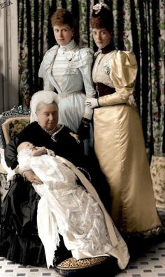 an old photo of three women dressed in period clothing and one is holding a baby