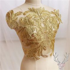 the back of a mannequin with gold sequins and flowers on it