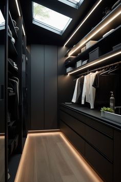 a walk in closet with lots of clothes hanging on the shelves and lights above it