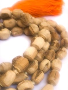 Tulsi (Tulasi) japa mala made from hand carved beads, hand knotted on white cotton thread, in Vrindavan, India. The beads are approximately 6mm to 9mm, with Large orange-colored cotton tassel. Total length is approximately 40 - 48 inches. Vrindavan grown, Vrindavan crafted.™ Use japa mala necklace as is, either as a necklace, prayer beads or a bracelet wrapped approximately six times around your wrist or use the beads for other crafting projects. The name "Tulasi" means "she who is incomparable. Brown Hand-strung Mala For Festivals, Tulasi Plant, Traditional Hand Knotted Mala With Round Beads, Tulsi Mala, White Hand-strung Mala With Round Beads, Multicolor Hand-strung Mala With Round Beads, Sacred Plant, Beauty Clothes, Mala Necklace