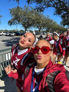 two women in red and white outfits are posing for the camera with their arms around each other