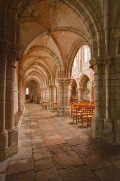 the inside of an old building with tables and chairs in it's center aisle